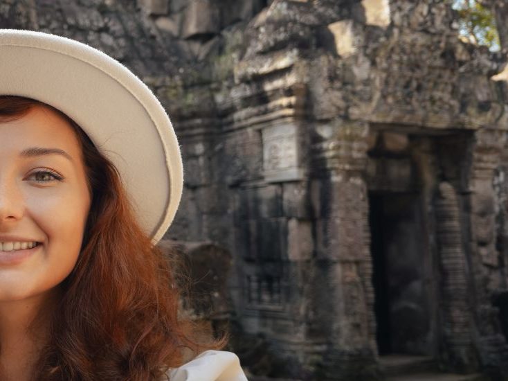 A selfie of a traveler smiling in front of ancient ruins